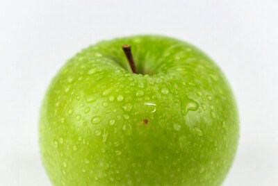 Green apple with water droplets