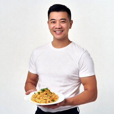 Asian man holding spaghetti plate