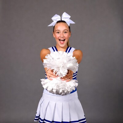 Cheerleader girl holding white pom poms