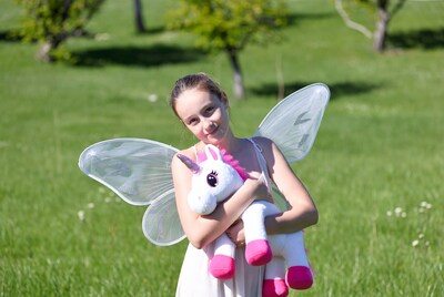Girl hugging unicorn in fairy wings
