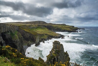 Dramatic Sea Cliffs with Waves and Green Hills