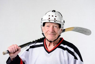 Elderly man in hockey gear with stick