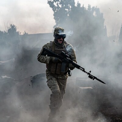 Soldier running with rifle in smoke