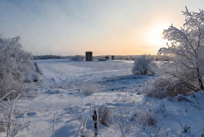 Snowy Farm with Grain Silos at Sunset