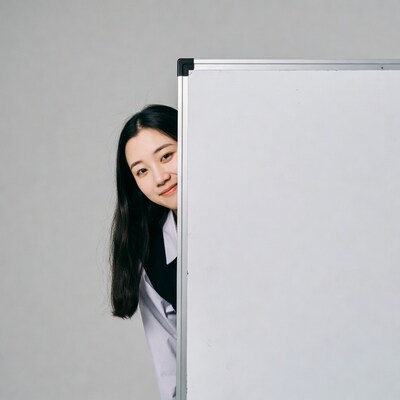 Asian woman peeking behind whiteboard