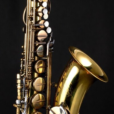 Shiny gold saxophone on black background