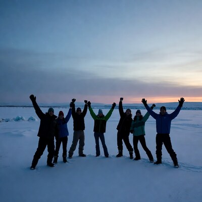 Group raising arms on icy tundra sunset