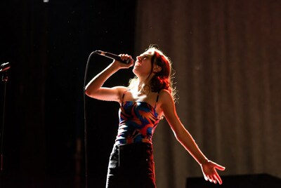 Woman singing passionately into microphone