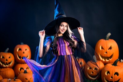 Woman in Witch Costume with Pumpkins
