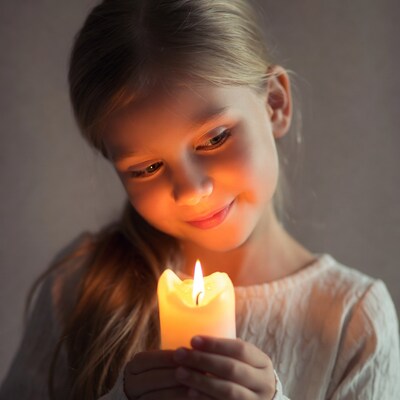Girl holding lit candle