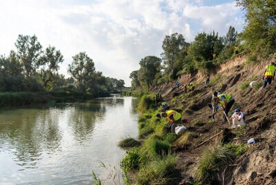 Workers cleaning riverbank trash