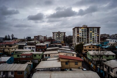 Colorful urban hillside neighborhood under clouds