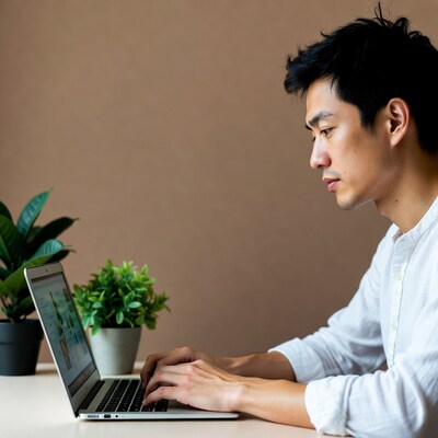 Asian man typing on laptop