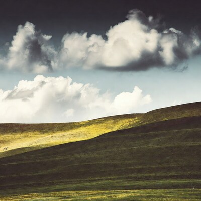 Rolling Green Hills Under Dramatic Clouds