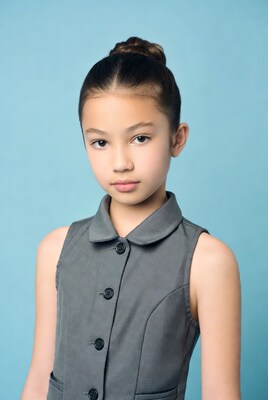 Asian girl in gray vest on blue background