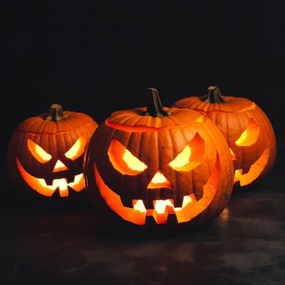 Three Lit Jack-o-Lanterns on Dark Background