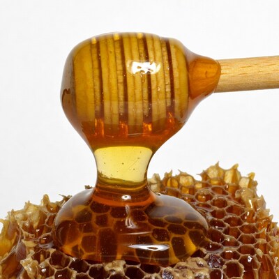 Honey dripping from wooden dipper