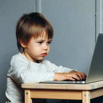 Toddler boy typing on laptop