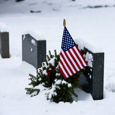 American flag on snowy gravestone