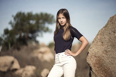 Teen girl hands on hips by rock