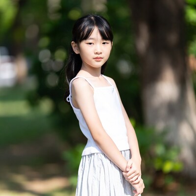 Asian girl in white tank top and skirt outdoors