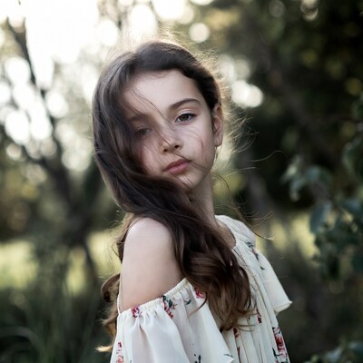 Girl in floral off-shoulder dress in woods