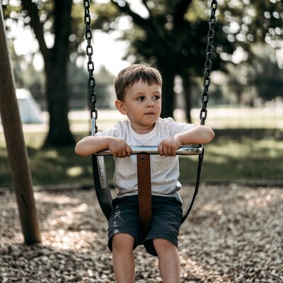 Boy sitting on playground swing