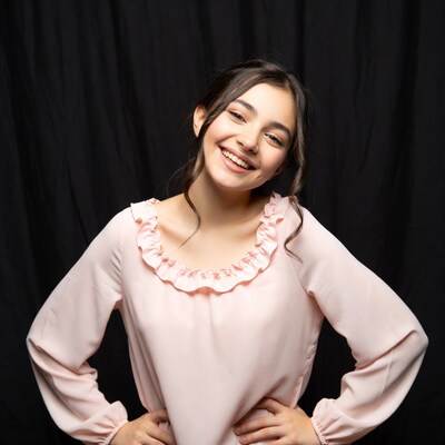 Smiling girl in pink blouse on black background