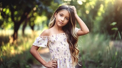 Girl in floral off-shoulder dress in forest