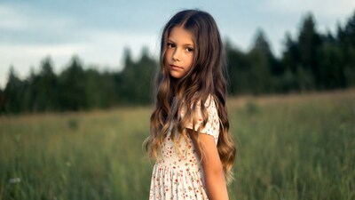Girl in floral dress in grassy field