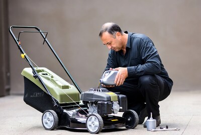 Man pouring oil into lawnmower engine