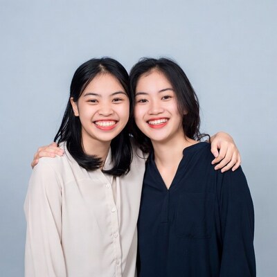 Two smiling Asian women hugging