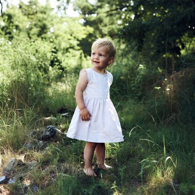 Blonde toddler girl in white dress forest