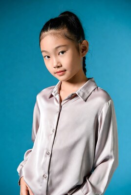 Asian girl in silk shirt on blue background