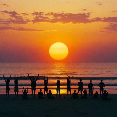 Silhouettes raising arms at sunset beach