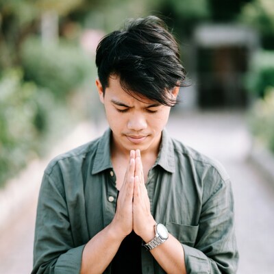 Asian man praying with hands together