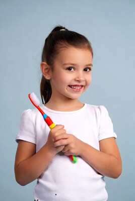 Girl holding red toothbrush