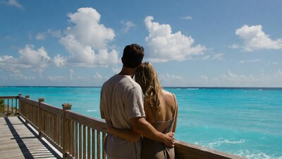 Couple embracing on pier over turquoise ocean