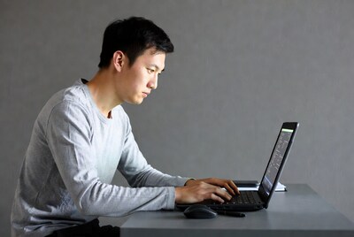Asian man typing on laptop