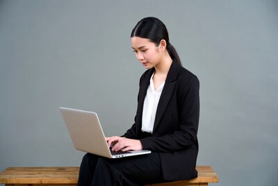 Asian woman typing on laptop
