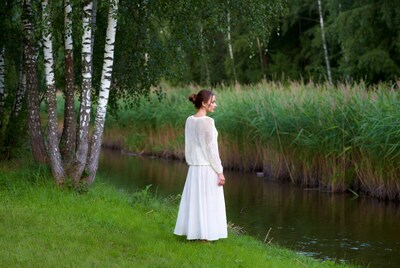 Woman in white dress by river