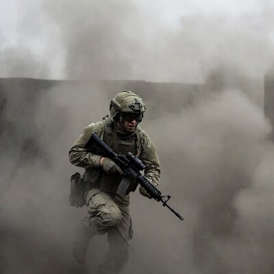 Soldier running with rifle in smoke