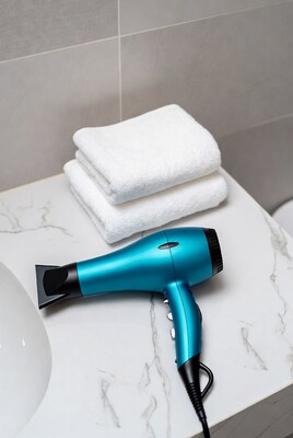 Blue hair dryer with towels on bathroom counter