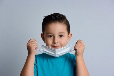 Boy holding white face mask