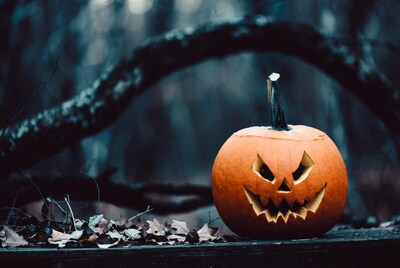 Jack-o'-lantern on wooden surface in dark forest