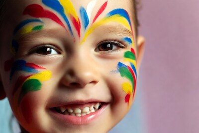 Boy with colorful face paint smiling