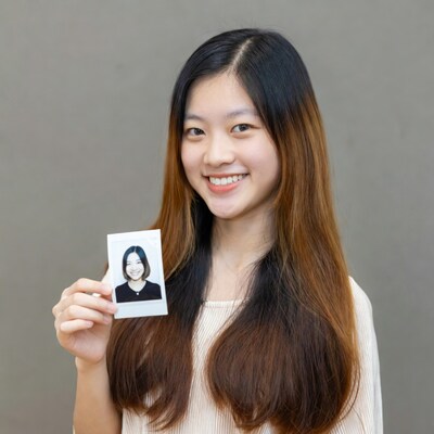 Asian girl holding Polaroid photo