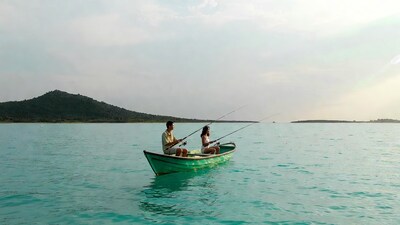 Couple fishing from green boat on lake