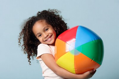African-American girl holding beach ball