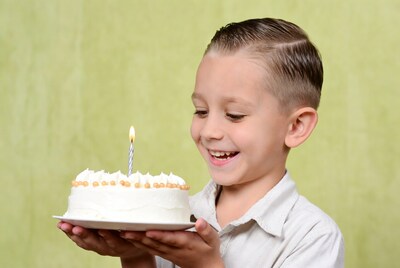 Boy holding birthday cake with candle